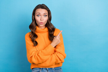 Photo of stunned shocked lady direct finger empty space not believe eyes wear knitted sweater isolated blue color background