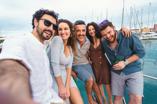 Group Selfie Fun on Boat Deck - A group of friends capture a fun and memorable moment with a group selfie on the deck of a boat. Their smiles and laughter