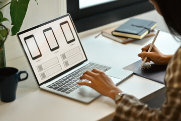 Side view of female website developer planning application development for web mobile phone at workplace