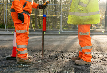 Site engineer surveyor and site manager discussing plan of works on construction site during new road construction