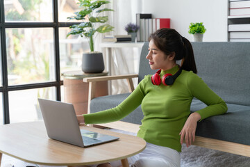 Young female student learning online or reading e-book with headphones and laptop computer in the room at home, Course online education from website or making video call concept.