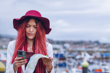 young tourist woman with map and mobile phone at sea port