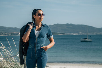 hispanic latin woman walking on the wooden boardwalk of the beach