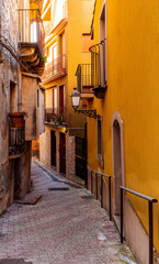 Fototapeta premium beautiful narrow medeterranean street with vintage buildings , beautiful windows and picturesque balcony with attributes of traditional italian country life