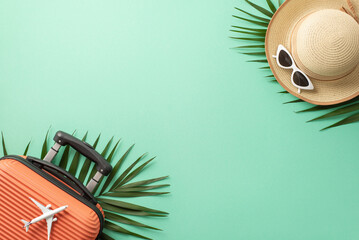 Summer vacation concept. Above view photo of plane model on orange suitcase and straw hat with white sunglasses and palm leaves on isolated teal background with copyspace