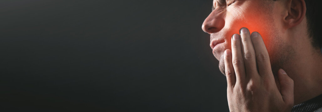 Caucasian man suffering from tooth pain.