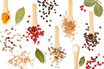Peppercorns, bay leaf, turmeric, salt and mustard seeds isolated on white.