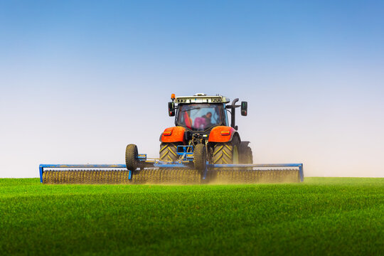 Tractor with a roller tillage on spring field. Soil rolling supports germination and is the basis for good harvesting, organic farming and agronomy
