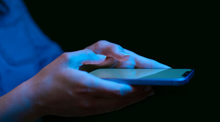 Close Up Of Woman Using Mobile Phone At Home At Night With Blue Lighting