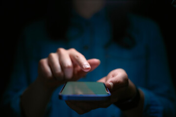 Close Up Of Woman Using Mobile Phone With Finger Poised Above Screen