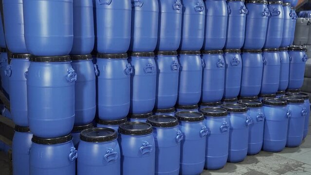 A close up group of Blue stacked Plastic chemical drums or Plastic Chemical barrels in the industrial warehouse.