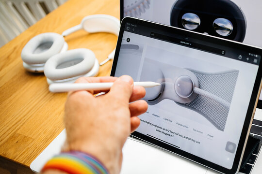 Paris, France - Jun 6, 2023: User with pencil pointing to external battery that supports up to 2 hours of use, for Apple Vision Pro mixed reality XR headset. Priced 3,499 USD - future of computing