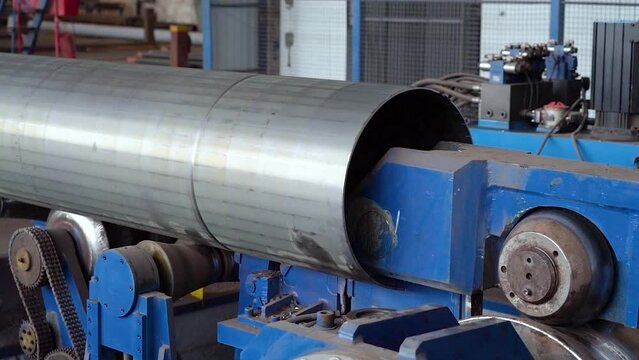 Pipe manufacturing plant. Pipe plant. Iron pipe welding. Pipe expansion. Sparks of welding. Tap. Factory. Machine tools. Production. Heavy industry.