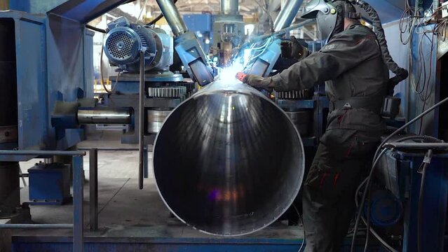 Tube manufacturing plant. Pipe metal. Sparks of welding. Machine tools. Production. Heavy industry.