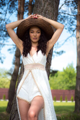 Beautiful woman in white summer dress and straw hat