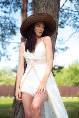 Beautiful woman in white summer dress and straw hat