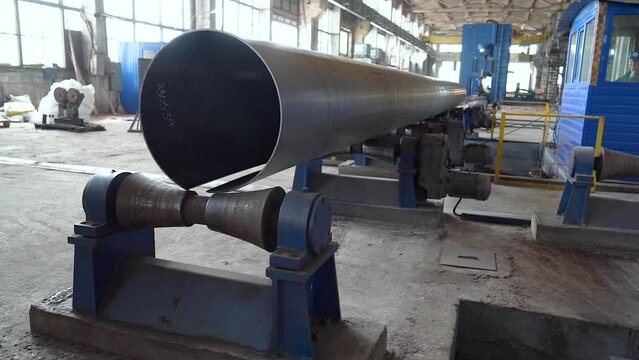 Pipe manufacturing plant. Pipe plant. Iron pipe welding. Pipe expansion. Sparks of welding. Tap. Factory. Machine tools. Production. Heavy industry.
