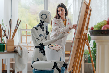 Woman teaching art to a robot