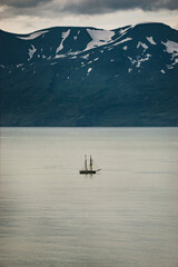 sailingboat in front of snowy mountains