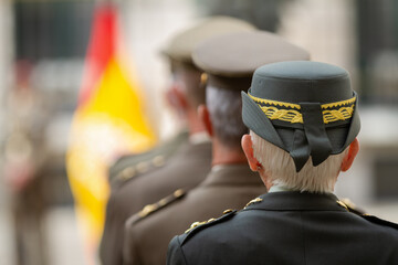 Vista de varios militares oficiales con sus gorras durante un desfile militar.
