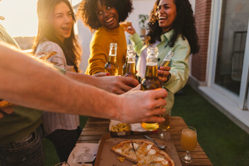 multiracial friends at rooftop party, toasting with beer, happy summer youth gathering, rental apartment,