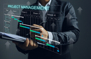 Fototapeta na wymiar Businessman holding clipboard and project management schedule plan for product production or Research and Development and recording weekly project progression.