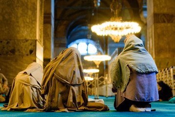 Islamic women with veil are seen praying inside a mosque in Istanbul covered with veil and kneeling