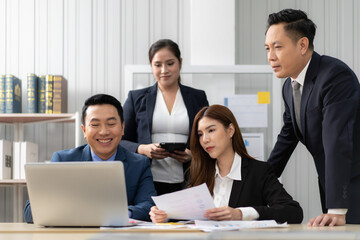 Business mentor meeting with team in office looking at computer screen training management concept. Asian businessman work together with executive colleague group talking mentoring leadership idea.