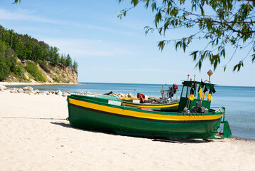Fototapeta na wymiar Green fishing boat on the shore.