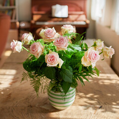 Closeup of bouquet of pink roses in a vase, flowers and nature on living room table, gift for romance or friendship. Plant, botanical and symbol of love, natural and floral arrangement at home