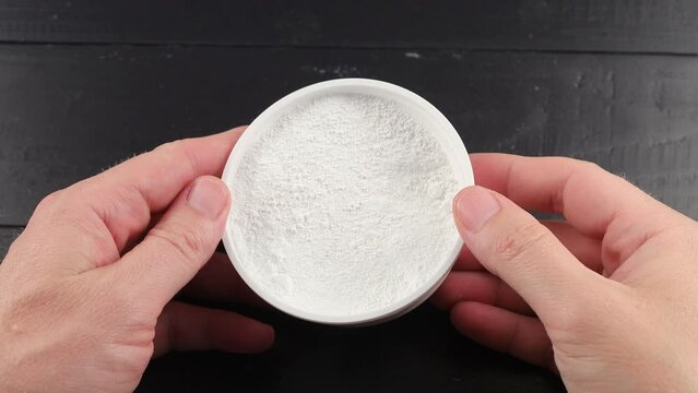 Tooth powder in a jar in hands