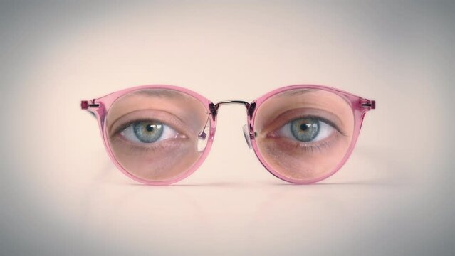 Female Glasses Eyes Look Zoom In. Isolated glasses with female human eyes looking, weird scene. Zoom in