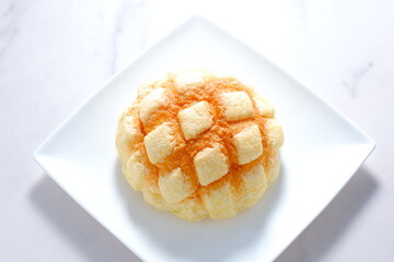 白いお皿の上の美味しそうなメロンパン