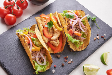 Mexican tacos with meat, pork carnitas street tacos in yellow corn tortilla with onion, cilantro and cabbage. red cabbage. Top view. flat lay.