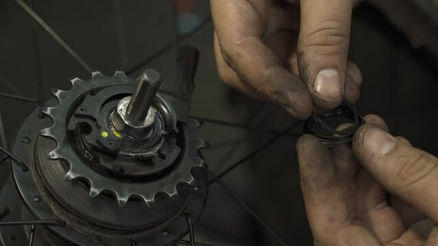 A bicycle mechanic repairing an internal hub gear system.
