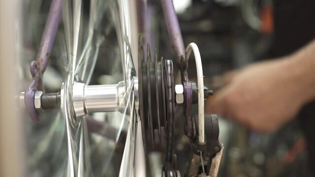 A bicycle mechanic adjusting the rear derailleur for gear shifting.