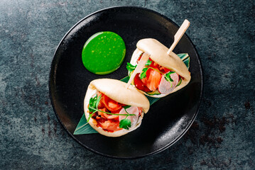 Asian burger, gua bao, made with Chinese brioche, salmon and vegetables on plate