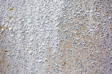 Texture of paint stains on the wall, cracked paint on an old metal surface. Sheet of silver metal with cracked and peeling paint, background for design with copy space.