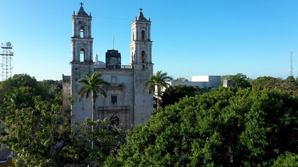 Fototapeta na wymiar Early morning aerial view over park fountain above trees and over the Cathedral de San Gervasio in Valladolid, Yucatan, Mexico.