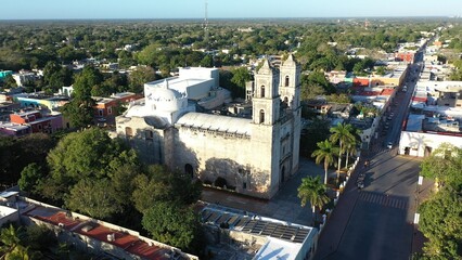 Fototapeta na wymiar Aerial to left showing Cathedral de San Gervasio and the city beyond after sunrise in Valladolid, Yucatan, Mexico.
