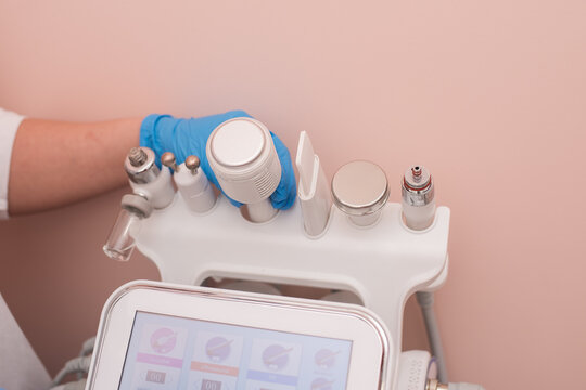 The cosmetologist includes a device for carrying out the procedure, attachments to the HydraFacial device for facial skin care in a spa clinic to combat acne or aging.