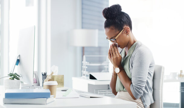 Sneeze, allergy and blowing nose with business woman in office for illness, virus and hay fever. Sick, allergies and tissue with female employee at desk for cold, disease and influenza infection