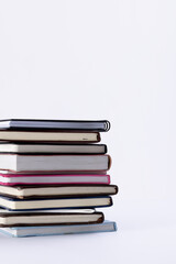 Close up of stack of books and notebooks with copy space on white background