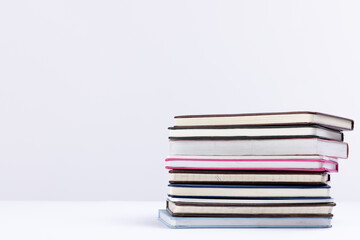 Close up of stack of books and notebooks with copy space on white background
