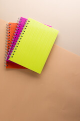 Flat lay of three notebooks with binding with copy space on orange background
