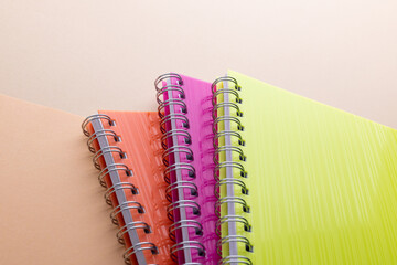 Flat lay of three notebooks with binding with copy space on orange background