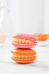 Colorful macaron cakes with cream filling on a table indoors, close-up