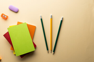 Flat lay of pencils, memo notes, sharpener and eraser with copy space on yellow background