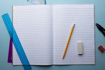 Close up of notebook with rulers and writing material on blue background