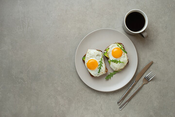 Toasts with egg and avocado on a gray background in a plate. healthy breakfast